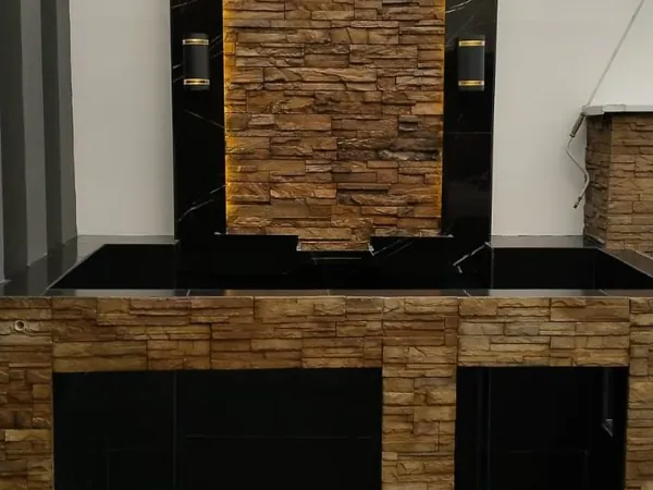 Terraza exterior con asador y muro de piedra decorativa
