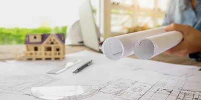 Planos y modelo arquitectónico sobre mesa de trabajo